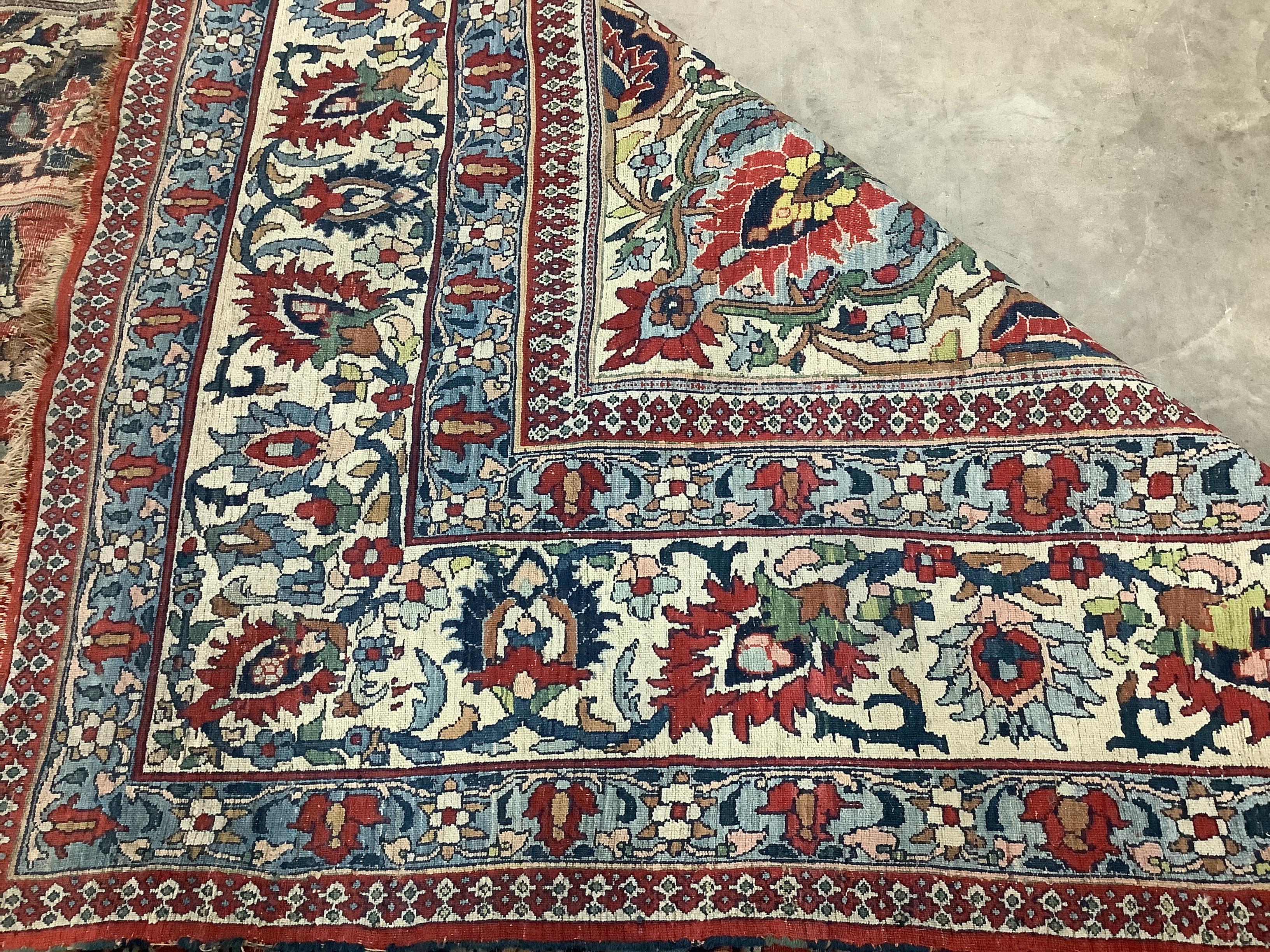 An early 20th century Heriz burgundy ground carpet, 380 x 276cm